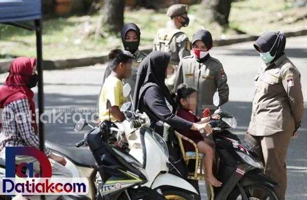 Salah seorang IRT yang membonceng anaknya menggunakan sepeda motor ditertibkan petugas karena langgar protokol kesehatan. (Foto: Istimewa)